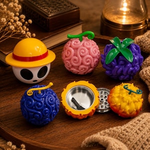 May include: A collection of six spherical containers and accessories inspired by One Piece. Items include a yellow straw hat figure, a pink swirl fruit, a purple fruit with green leaves, a blue swirl fruit, and an open orange fruit with a metal grinder.
