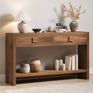 May include: A rectangular wooden console table with a dark brown finish, featuring two drawers with square wooden pulls. The table includes a lower shelf for storage and a flat top surface. The wood grain is visible throughout the entire structure.