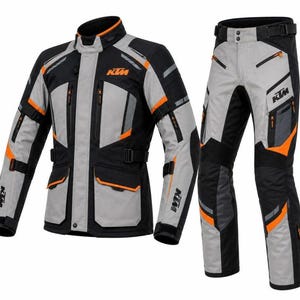 Könnte beinhalten: Ein Motorradjacken- und Hosenset in Schwarz, Grau und Orange. Die Jacke verfügt über einen hohen Kragen, mehrere Reißverschlusstaschen und das KTM-Logo auf Brust und Ärmeln. Die Hose enthält einen verstellbaren Hüftgurt und Reißverschlusstaschen.