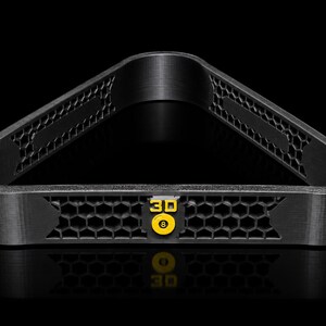 May include: A black triangular billiard ball rack featuring a textured honeycomb pattern along its sides. The front center of the rack displays a yellow emblem with the text 3D and an image of an eight ball, providing a distinct visual focal point.