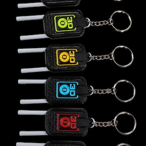 May include: Six rectangular black keychains with two white prongs extending from the left side. Each keychain features a central colored outline of a billiard ball with the number 8 and the text 3D. Colors include pink, lime, yellow, blue, red, and orange.