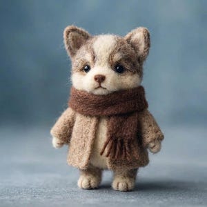 以下が含まれることがあります： 茶色と白の毛並みをした子犬のようなニードルフェルトの動物フィギュア。ベージュの質感のあるコートを着て、首にはフリンジ付きのダークブラウンのマフラーを巻いています。暗い色の目、小さな茶色の鼻、尖った耳が特徴です。