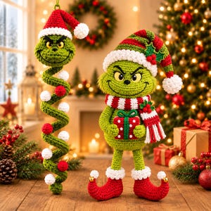 May include: A green crocheted character with a grumpy expression, wearing a red and white Santa hat and scarf, holding a red gift box with white dots. Beside it is a long, green, spiral-shaped crocheted ornament with white and red pom-poms.