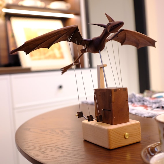 A hand-carved walnut automaton where a dragon's wings actually flap — one craftsperson, months of work, zero CNC shortcuts.