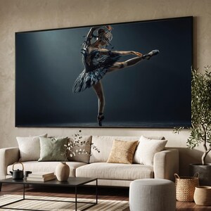 May include: A large rectangular wall art print featuring a ballet dancer in a black feathered costume and an ornate headpiece, captured in a dynamic pose against a dark background, displayed in a black frame above a beige sofa.
