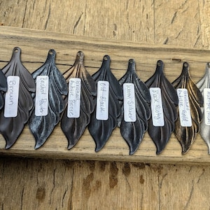 May include: Ten different metal leaf-shaped pulls in various finishes, including black, brown, brushed pewter, antique bronze, old black, warm silver, black rusty, antique gold, antique nickel, and oil bronze.
