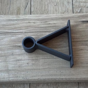May include: Black metal triangle shelf bracket with a round pipe fitting. The bracket is designed to be mounted to a wall or other surface.