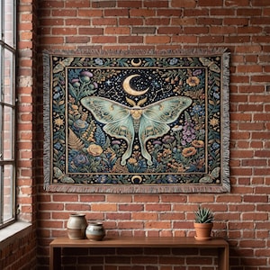 Puede incluir: Un tapiz tejido rectangular que presenta una gran polilla de color verde pálido en el centro, rodeada por un cielo nocturno azul oscuro con una luna creciente, estrellas y un borde vibrante de flores coloridas, follaje y polillas pequeñas.