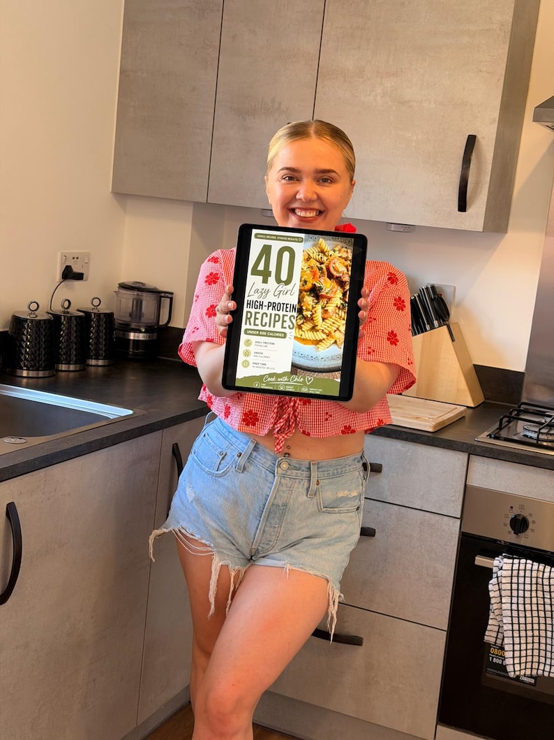 K&ouml;nnte beinhalten: Ein digitales Tablet, das ein Kochbuch-Cover mit dem Titel 40 Lazy Girl High-Protein Recipes Under 500 Calories anzeigt, mit einem Foto von Pasta mit Tomaten und Kr&auml;utern sowie dem Text Cook with Chloe am unteren Bildschirmrand.