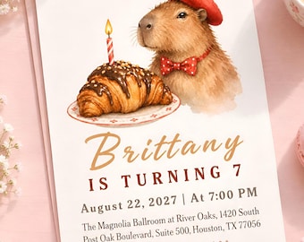 Könnte beinhalten: Eine Geburtstagseinladungskarte mit einer Aquarellillustration eines Capybaras, das ein rotes Barett und eine rot gepunktete Fliege trägt, neben einem mit Schokolade überzogenen Croissant mit einer brennenden Kerze. Der Text lautet: Brittany IS TURNING 7, August 22, 2027 | At 7:00 PM, The Magnolia Ballroom at River Oaks, 1420 South Post Oak Boulevard, Suite 500, Houston, TX 77056, RSVP: 555-486-7452.