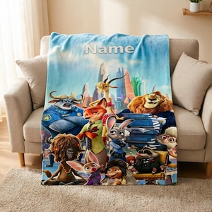 May include: A soft fleece throw blanket featuring a colourful Zootopia movie scene with characters including Judy Hopps, Nick Wilde, Chief Bogo, and Mayor Lionheart against a city skyline. The word Name is printed in white at the top centre.