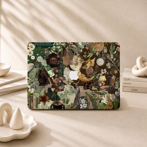 May include: A laptop skin featuring a dark green and brown collage of vintage elements including a crescent moon, a pocket watch, a frog, a cup of coffee, flowers, butterflies, a record player, and a small green music player with text.