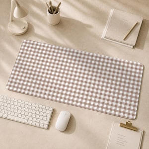 Puede incluir: Una alfombrilla de escritorio rectangular con un patrón de cuadros vichy en color marrón y blanco. La alfombrilla tiene esquinas redondeadas y una superficie lisa, diseñada para colocarse sobre una superficie de trabajo bajo el teclado y el ratón.