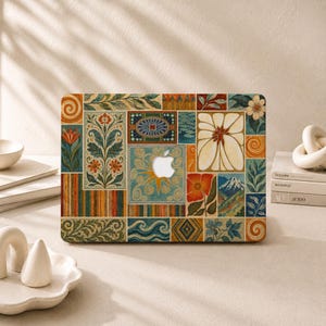May include: A laptop skin featuring a collage of rectangular panels with diverse illustrations including floral motifs, swirling patterns, geometric shapes, a mountain landscape, and a central cutout revealing the silver Apple logo.