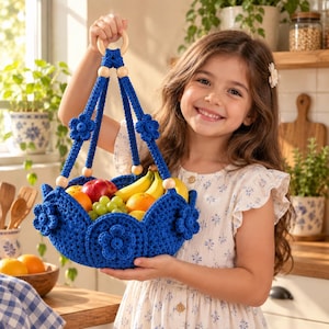 May include: A vibrant blue crocheted hanging basket featuring a circular wooden ring at the top, decorative crocheted flower accents on the sides, and natural wooden beads along the suspension cords, filled with assorted fresh fruit like bananas and apples.