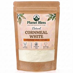 Könnte beinhalten: Ein brauner Standbeutel mit weißem Maismehl. Das Etikett enthält den Text Planet Bless, Natural CORNMEAL WHITE, HANDMADE | PURE | NATURAL, 100% NATURAL, CHEMICAL FREE und HANDMADE WITH CARE sowie Blatt- und Herzsymbole.