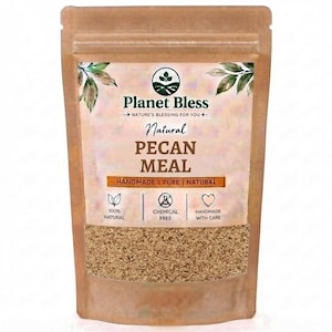 Pode incluir: Uma bolsa vertical castanha contendo farinha de noz-pecã. O rótulo apresenta o texto Planet Bless, Natural PECAN MEAL e Handmade, Pure, Natural. Ícones indicam 100% Natural, Chemical Free e Handmade with Care, com detalhes de folhas verdes.