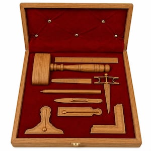 Könnte beinhalten: Eine hölzerne Präsentationsbox mit rotem Samtinnenfutter, die einen Holzhammer, ein 15-cm-Lineal, einen Stift, einen Brieföffner, ein T-Winkel, ein Winkelmaß und weitere Holzwerkzeuge enthält, die in passgenauen Aussparungen liegen.