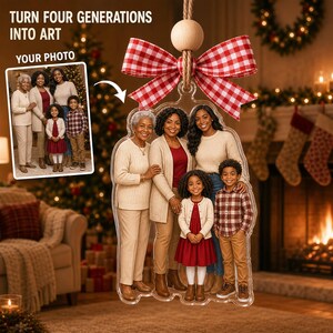 May include: A clear acrylic ornament featuring a printed family portrait of four generations. The ornament is topped with a red and white gingham ribbon bow and a natural wooden bead, suspended by a jute twine loop for hanging on a tree.