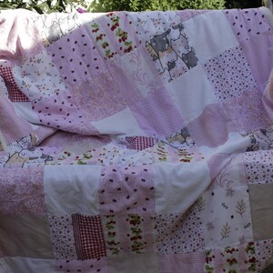 Pink and white patchwork blanket with cat motifs and a fleece backing with cherries; pink Cherry Cat Blanket