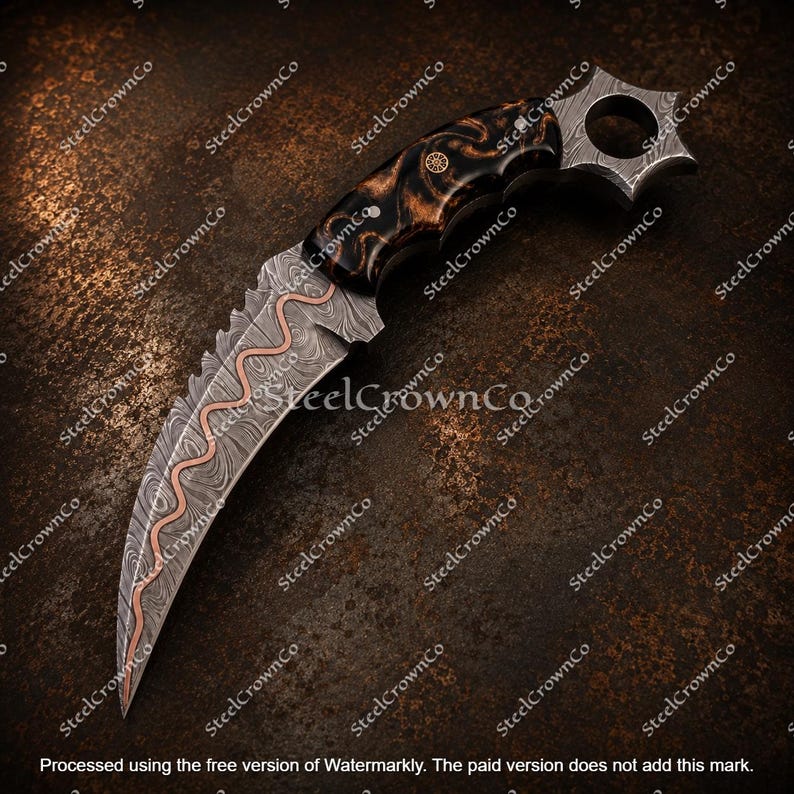 Puede incluir: Un cuchillo karambit curvo con una hoja de acero damasco estampada y una incrustaci&oacute;n central de cobre ondulado. El mango est&aacute; hecho de madera oscura veteada con un anillo circular para el dedo en el pomo. La hoja tiene sierra cerca de la empu&ntilde;adura.