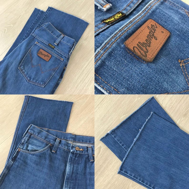May include: Blue denim jeans with a classic five-pocket design. Features a brown leather patch with the "Wrangler" logo on the back pocket. The jeans have a straight leg cut and a button and zipper closure.