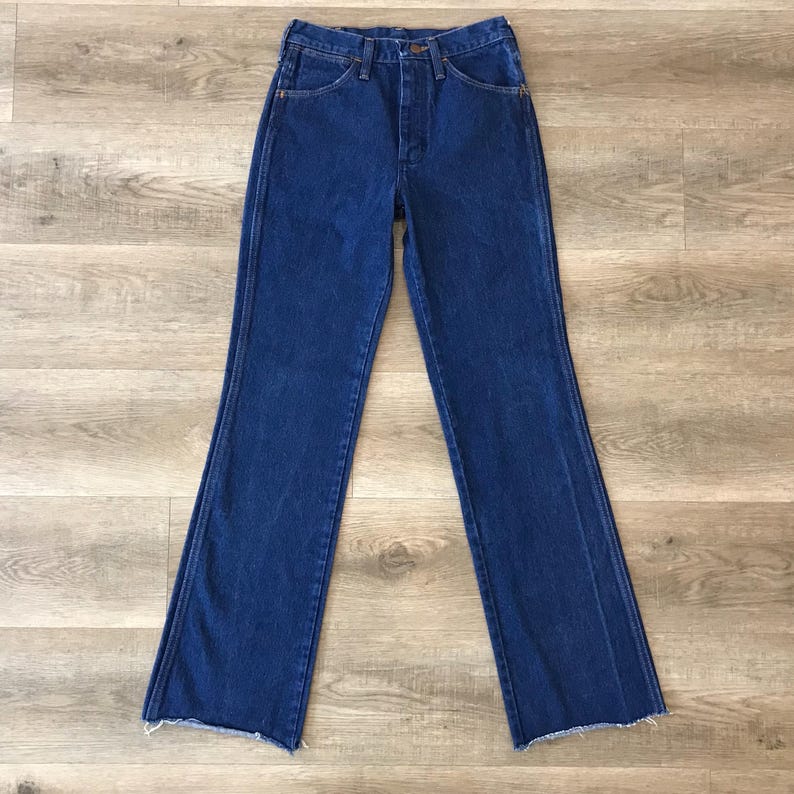 May include: A pair of blue denim jeans with a high waist and a wide leg. The jeans have a button fly and belt loops.