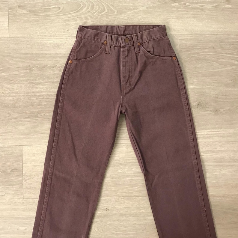 Op de afbeelding: Een paar mauvekleurige jeans. De jeans hebben een klassiek ontwerp met vijf zakken en een knoop- en ritssluiting. De jeans zijn gemaakt van stevig denim en hebben een rechte pijp.