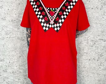 Camiseta vintage de los 90 con estampado de manzanas y cuello a cuadros.