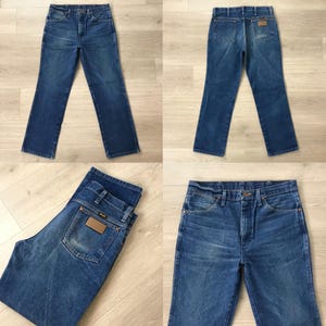 May include: Four views of blue denim jeans. The jeans have a classic five-pocket design, a button and zipper closure, and a brown leather patch on the back pocket. The denim has a faded appearance.