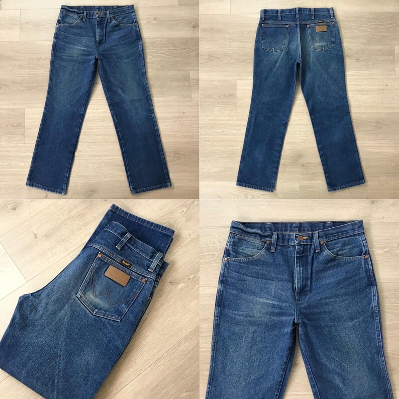 May include: Four views of blue denim jeans. The jeans have a classic five-pocket design, a button and zipper closure, and a brown leather patch on the back pocket. The denim has a faded appearance.