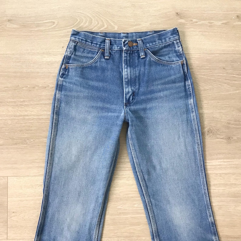 Op de afbeelding: Een lichtblauwe spijkerbroek met een klassiek vijf-zakken ontwerp. De jeans heeft een knoop- en ritssluiting en een rechte pijp. De denim heeft een vervaagde uitstraling, met subtiele slijtplekken.