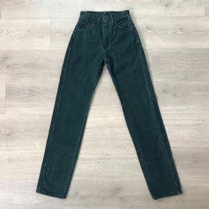 Op de afbeelding: Donkergroene denim jeans met een klassiek vijf-zakken ontwerp. De jeans hebben een hoge taille en een rechte pijp. Het denim lijkt van een gemiddeld gewicht te zijn. De jeans liggen plat op een licht houten oppervlak. Tailleomvang: 76 cm.