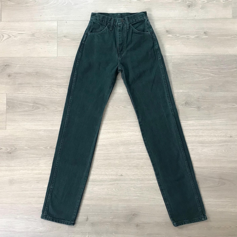 Op de afbeelding: Donkergroene denim jeans met een klassiek vijf-zakken ontwerp. De jeans hebben een hoge taille en een rechte pijp. Het denim lijkt van een gemiddeld gewicht te zijn. De jeans liggen plat op een licht houten oppervlak. Tailleomvang: 76 cm.