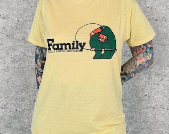 Camiseta vintage suave y desgastada de los años 70 con estampado de pájaro y dentista familiar.