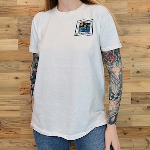 May include: White t-shirt with a colorful patch on the left chest. The patch reads "Camp Raven Knob, Old Hickory Council, USA".