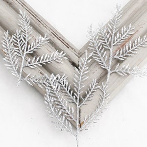 May include: Silver glitter sprigs, perfect for adding a touch of sparkle to your holiday decor. These sprigs are made of wire and have a delicate, feathery texture.