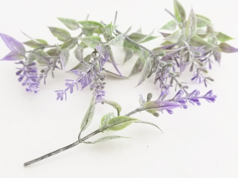 K&ouml;nnte beinhalten: Ein Bund k&uuml;nstlicher Lavendelzweige mit gr&uuml;nen Bl&auml;ttern und violetten Bl&uuml;ten.