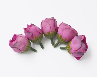 May include: Five small pink artificial rose buds with green stems.
