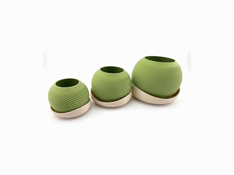 Three matcha green spiral Saddle Pot planters in cream drip saucers lined up from small to large