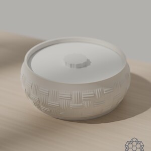 Alabaster white woven storage bowl with white drop-in lid on a sunlit table. 3D-rendered visualization of the exact print file.