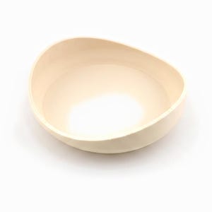 Empty cream drip saucer shown on its own against a white background