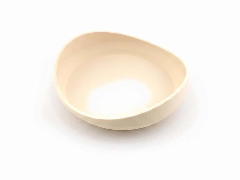 Empty cream drip saucer shown on its own against a white background