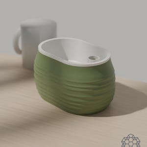 Aquaoval planter in matcha green beside a plain white mug for scale, on a sunlit wooden table. Images include 3D-rendered visualizations of the exact print files.