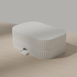 May include: A matte white rectangular storage box with rounded corners and a ribbed, vertical texture along the sides. The container features a two-part design with a lid and a small, protruding tab on the front edge for opening the lid.