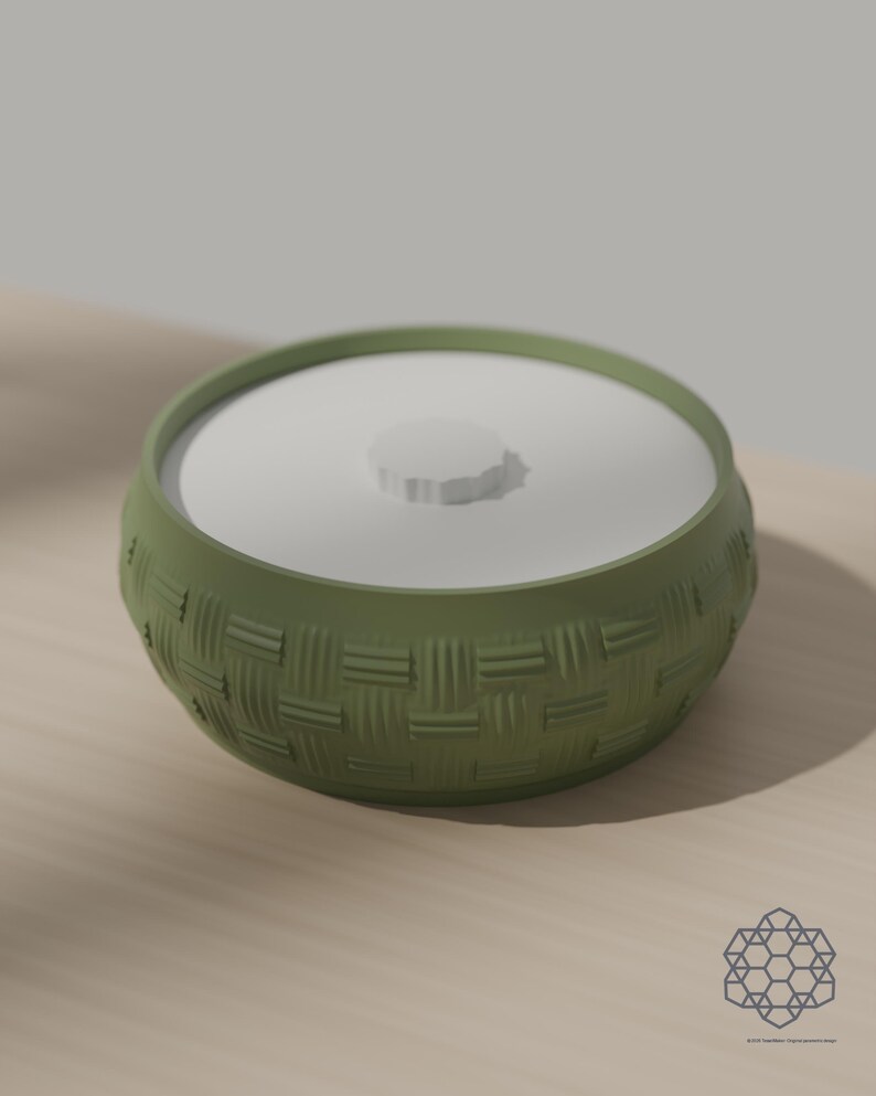 Matcha green storage bowl with a woven basket texture and a white drop-in lid, on a sunlit wooden table. 3D-rendered visualization of the exact print file.