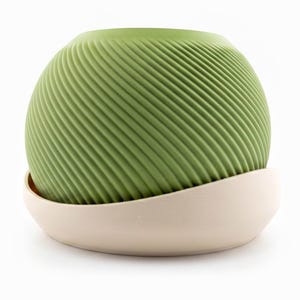 Medium matcha green Saddle Pot spiral planter resting in its cream drip saucer
