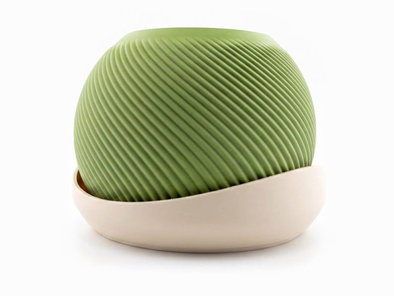 Medium matcha green Saddle Pot spiral planter resting in its cream drip saucer