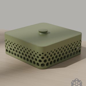 May include: A square olive green storage box with a matching lid featuring a central knob. The sides of the box are decorated with a perforated pattern of circular cutouts that vary in size, creating a gradient effect along the perimeter.