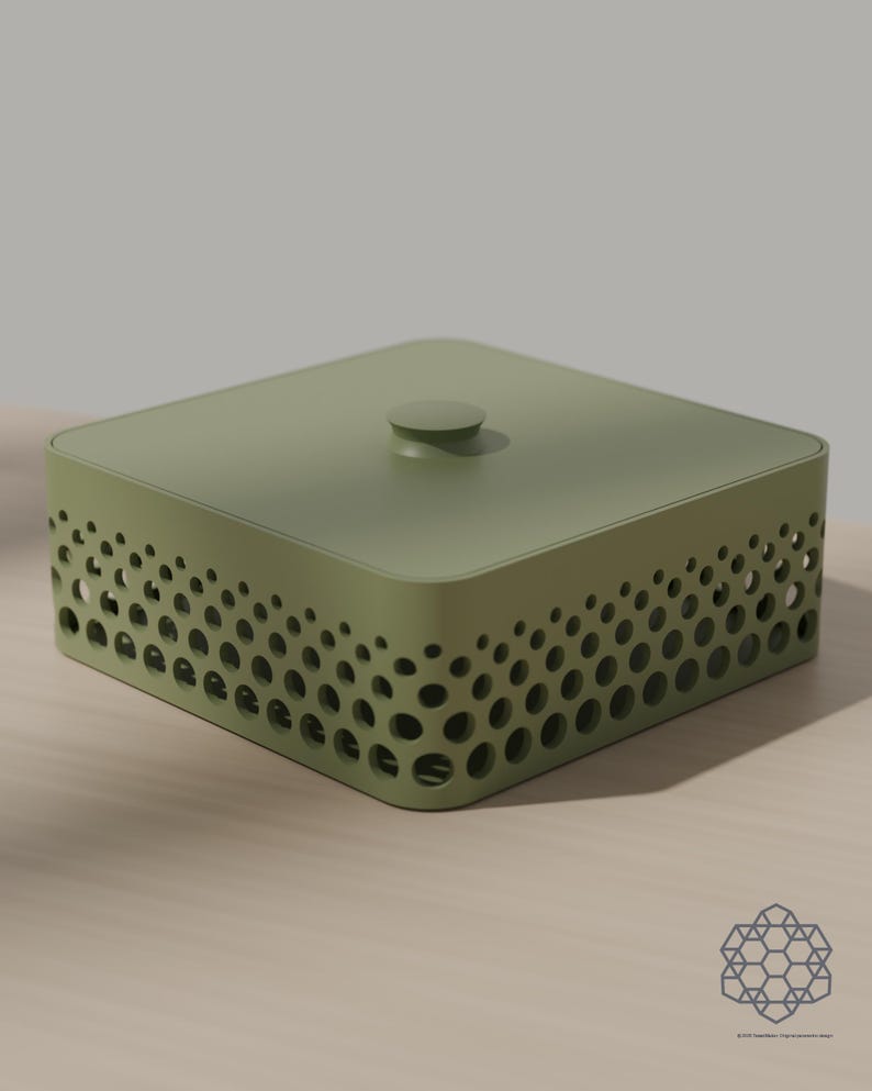May include: A square olive green storage box with a matching lid featuring a central knob. The sides of the box are decorated with a perforated pattern of circular cutouts that vary in size, creating a gradient effect along the perimeter.
